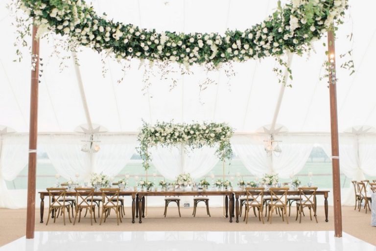 https://yannidesignstudio.com/app/uploads/2019/12/greenery-garden-themed-wedding-ceremony-reception-guest-table-decor-suspended-floral-arch-centerpieces-candles-lights-decoration-ideas-arranmore-farm-and-polo-club-chicago-suburbs-venue-768x513.jpg